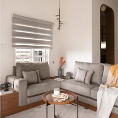 A custom-built L-shaped sofa with unique leather strap details provides ample seating in this living room. The design merges craftsmanship with function, creating a cohesive and sophisticated environment.