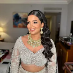 A close-up of Shreya's reception makeup, showing her radiant smile and the soft, shimmering tones on her eyes.