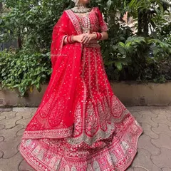 A classic red bridal lehenga with intricate gold embroidery. This timeless piece is perfect for the main wedding ceremony.