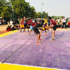 A raider from our academy attempts a kick touch during a competitive match on a purple mat, showcasing the athletic ability we nurture.
