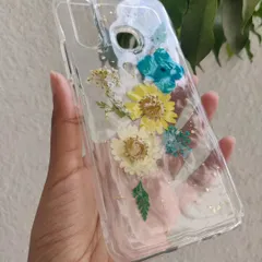 A custom phone case made with real dried flowers. I arranged these yellow and blue daisies and added a sprinkle of gold leaf to create a beautiful, botanical design.