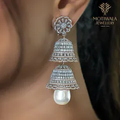 A modern take on a classic form. These tiered jhumka earrings are crafted entirely from diamonds with a lustrous pearl drop, blending traditional silhouettes with contemporary brilliance.