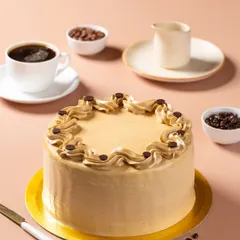 A coffee-flavored cake, styled with a cup of black coffee and coffee beans to communicate its flavor profile visually.