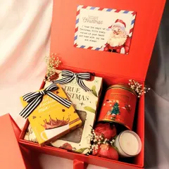 Spread the joy this Christmas with a festive red hamper. This box is filled with hot chocolate mix, cookies, a scented candle, and a cute Santa card.