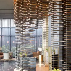 A wide shot of the modular facade at the Godrej South Estate centre. This semi-permeable curtain of layered MDF plates creates a stunning visual anchor, balancing a sense of openness with intrigue.