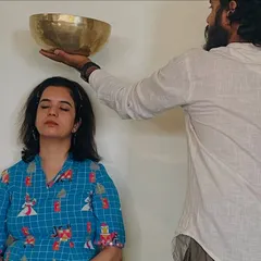 Here, I am performing a specific sound healing technique, placing a singing bowl near the crown chakra. This helps to clear mental clutter, reduce anxiety, and improve clarity and focus.