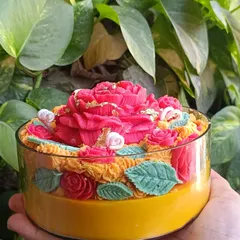 My rose garden jar candle is a vibrant and intricate piece. It features a large central rose surrounded by smaller roses and leaves, with gold leaf accents, all within a large glass jar.