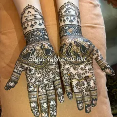 This Sawan festival mehndi is packed with detail, featuring dancing peacocks and a dense floral pattern. I also personalized it by hiding the names 'Anuj' and 'Pooja' in the design, a special touch I love to add.