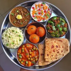 A festive thali for when you crave something extra special. This spread includes jeera rice, aloo mutter, shimla mirch bhaji, dal makhani, boondi raita, ghee parathas, and sweet gulab jamun for a perfect finish.