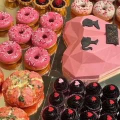 A close-up of the dessert table from our Barbie party. We included pink-glazed donuts, a geometric heart smash cake, rich chocolate cupcakes, and even pink-themed Korean cream cheese buns.