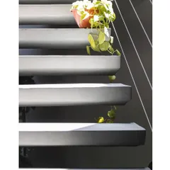 A close-up of the concrete steps, showing their clean, wedge-like profile. The smooth concrete finish and sharp lines are key to its minimalist aesthetic.