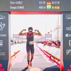 Crossing the finish line with his time displayed on the board. This image captures the proud moment of our athlete completing the Ironman 70.3 Middle East Championship.