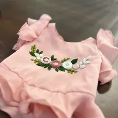 A full view of the hand-embroidered floral detail on a ruffled top for kids, showcasing our craftsmanship on a smaller scale.