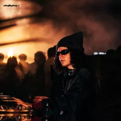 DJ Carlita at the decks during Zamna India in Bangalore, surrounded by warm, hazy light and smoke. This shot captures the cool, focused vibe of her set.
