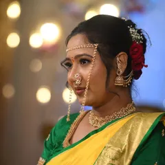 This profile shot captures the elegance of the bride's makeup and hairstyle. The red roses in her hair add a classic touch to the traditional Maharashtrian look.