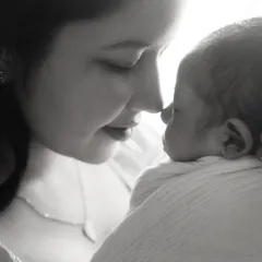 An intimate black and white close up of a mother and her newborn. This style emphasizes the emotional bond and the delicate features of the baby.