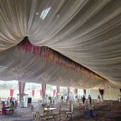 The grand scale of a wedding marquee we helped bring to life. The flowing drapes, magnificent chandeliers, and spacious seating arrangement create a breathtaking ambiance for a truly memorable wedding reception.