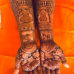 A personalized bridal mehendi featuring the couple's initials, the wedding date, and traditional motifs like peacocks and dhol drums.