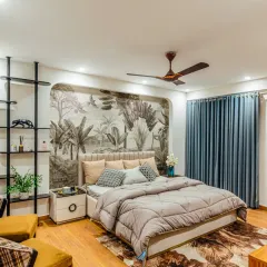 This bedroom is a serene retreat where art meets architecture. The custom botanical wallpaper creates a stunning feature wall, complemented by warm wood flooring, layered lighting, and bespoke furniture to craft a space that feels both elegant and deeply personal.