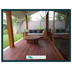 The quality of the flooring sets the foundation for the entire space. This covered patio features stunning Ipe wood decking, known for its durability and deep reddish-brown color. It provides a warm, natural, and luxurious base for the outdoor lounge area.