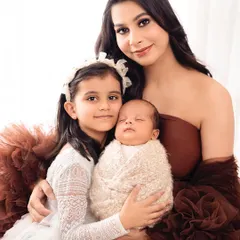 A mother and her two daughters, one a proud big sister and the other a brand new arrival. This is a beautiful way to capture your family's new chapter.