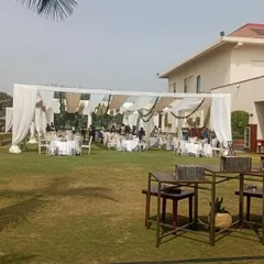 This wide shot shows a complete outdoor event space I put together. It includes a large draped tent for dining and seating, with plenty of open lawn space for guests to mingle, demonstrating my ability to manage large venues.