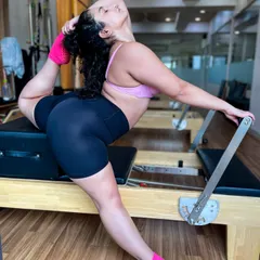 Discover true flexibility and uniformly developed strength with our reformer Pilates sessions. This pose demonstrates the deep, controlled stretching that lengthens muscles and improves overall body conditioning.