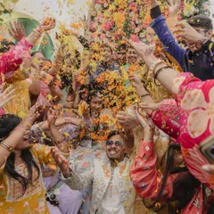 The pure, unadulterated joy of celebration. This shot from a Haldi ceremony, with friends and family showering the groom in a burst of colorful flower petals, is the kind of energetic and candid moment we love to capture. It’s the laughter and chaos that make a wedding truly alive.