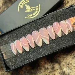 A modern and artistic press-on set in an elegant almond shape. This design features a sheer pink base with bold, free-flowing white swirls for a minimalist yet eye-catching look.