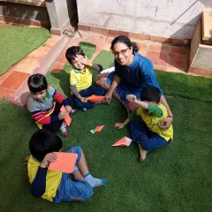 Soaking up some Vitamin D while learning the art of origami. This outdoor craft session combines the benefits of fresh air with an activity that enhances concentration and spatial reasoning.