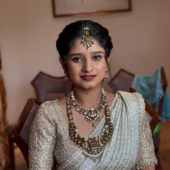 A close-up of Ramya, the sister of the bride. Her makeup is fresh and youthful, with a focus on glowing skin and a pretty berry lip.