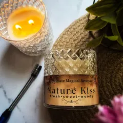 The 'Nature Kiss' Crystal Jar Candle, shown here with its double wick lit. This fresh, sweet, and woody scent feels like a breezy morning in a lush forest.