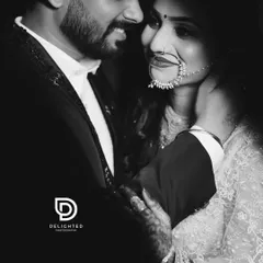 An intimate black and white close-up. This portrait focuses on the couple's connection, the groom's hand gently holding her neck as they share a quiet moment.