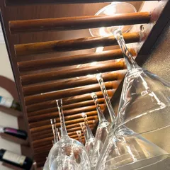 A close-up of a custom-built wooden glass rack in a home bar. This simple, slatted design is both a practical storage solution and a beautiful detail that enhances the overall aesthetic.