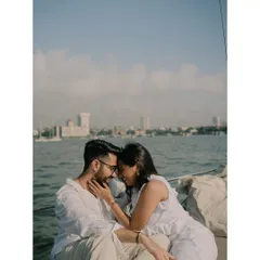 A quiet, intimate moment on the water. The Mumbai cityscape provides a stunning backdrop, but their connection is the real focus.