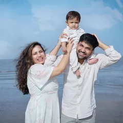 A playful family moment on the beach, with the baby held high in the air. Our outdoor sessions are perfect for capturing candid, joyful family interactions.
