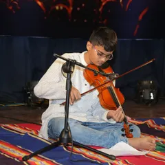 A close-up of Amogh's focused expression and skillful playing during his violin recital at Kalaa Sangama.