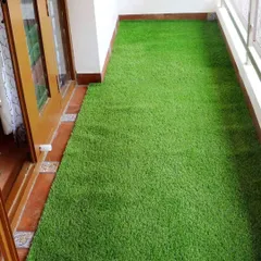Here is an artificial grass installation in a long, narrow balcony. It instantly makes the space look cleaner and more inviting, turning it from a simple walkway into a pleasant area to enjoy.