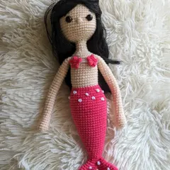 A beautiful handmade mermaid doll with long black hair and a pink tail. A magical gift for anyone who loves the sea.