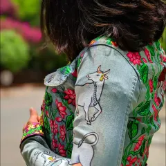 This denim jacket features a hand-painted design inspired by traditional Pichwai art. I depicted the sacred cow, Kamdhenu, surrounded by blooming lotuses, bringing a touch of timeless Indian heritage to modern fashion. The details on the sleeves and cuffs complete the narrative.