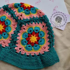 A close-up of the intricate floral granny squares that make up our popular bucket hat. We love how the teal, pink, and yellow colors work together.