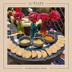 A sophisticated wine and cheese station I set up for my client, ALSORG. The display includes a variety of hummus and pita, with colorful flowers in bottles adding a stylish touch.