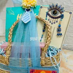 For Raksha Bandhan, I believe in gifting an experience. This premium hamper for a brother and sister-in-law features a beautiful evil eye rakhi set, a makeup kit from Enn Beauty, and a box of dry fruits, all presented in a stylish, handwoven kauna grass basket.