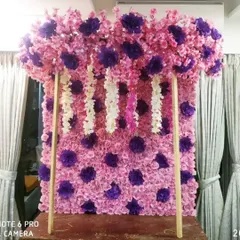 This is a ready-made floral panel featuring a pink and purple polka-dot pattern made from artificial flowers. It's a fun and colorful option for a quick and easy backdrop.