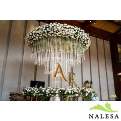 This custom floral chandelier, featuring the couple's initials "A R" in gold, served as a stunning centerpiece. This type of personalized branding is perfect for making a corporate event or launch feel unique and exclusive.