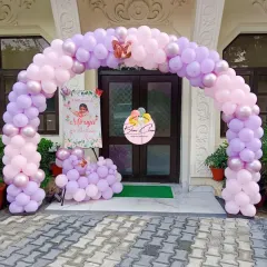 A delicate pastel pink and purple balloon arch framing an entrance, perfect for a princess or butterfly-themed party.