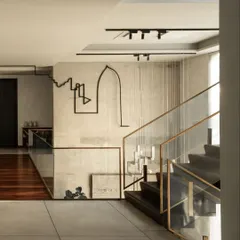 The sculptural line installation as it navigates the staircase, casting dynamic shadows that change with the light. This demonstrates how we use art to create an experience that evolves as you move through the space.