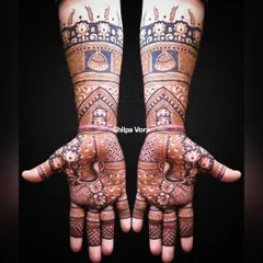 This full-arm bridal design is a masterpiece of traditional art, featuring domes, peacocks, and intricate patterns from fingertips to elbow.