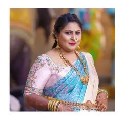 Elegance at any age. This client looks radiant in a custom light pink blouse with colorful floral embroidery along the neckline and sleeves, perfectly matching her beautiful blue and cream silk saree.