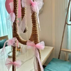 Detail of a decorated swing for the bridal shower. I wrapped the ropes in jute and adorned them with delicate pink tulle bows to match the event's color scheme.